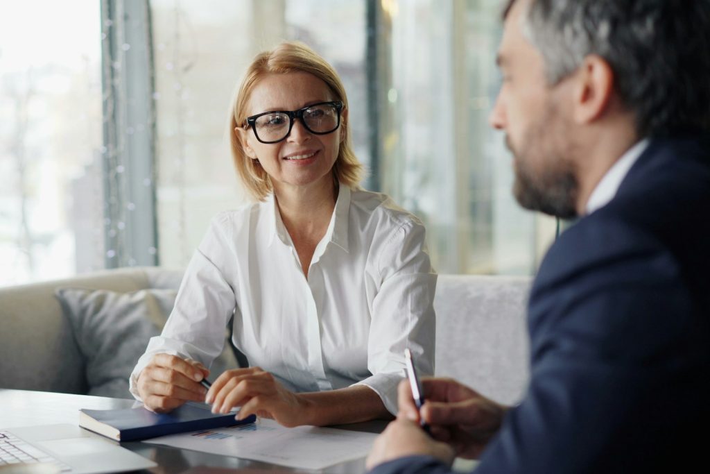 A couple meeting an advisor at a table with a laptop