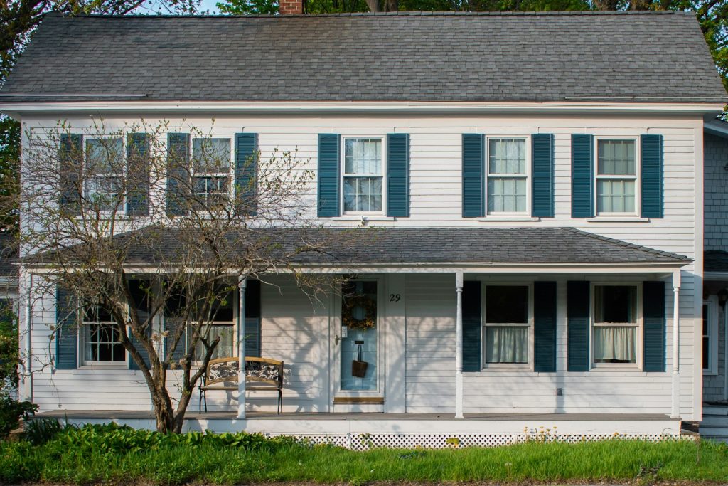 A white house with blue shutters and a front porch
